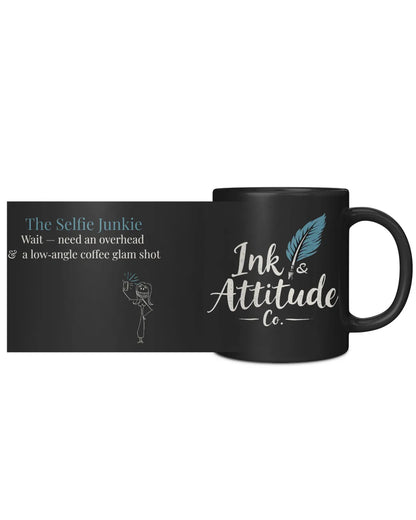 Black coffee mug featuring "The Selfie Junkie" text and a playful illustration, branded with Ink & Attitude Co. logo.
