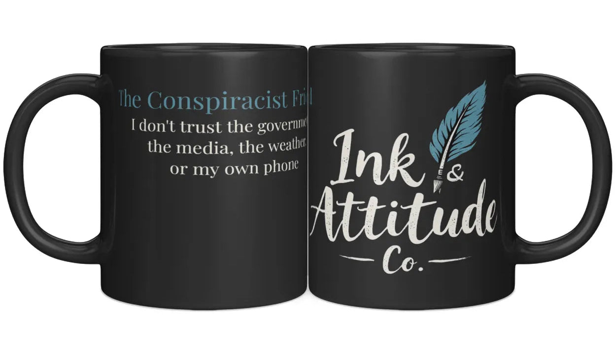 Black ceramic mug featuring "The Conspiracist Friend" text on one side and "Ink & Attitude Co." logo on the other.