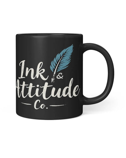 Black mug featuring the text "Ink & Attitude Co." with a blue feather quill design. Ideal for writers and creatives.