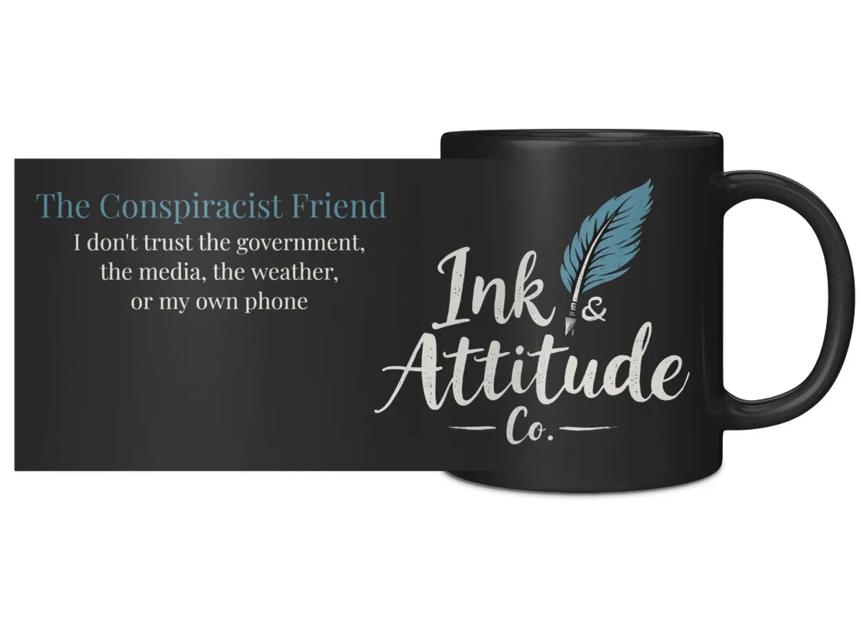 Black ceramic mug featuring the text "The Conspiracist Friend" and the Ink & Attitude Co. logo with a feather design.