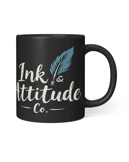 Black coffee mug featuring "Ink & Attitude Co." text and a feather design. Ideal for coffee lovers with a playful spirit.